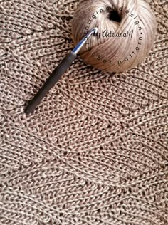 a ball of yarn sitting on top of a table next to a crochet hook