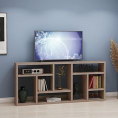 a flat screen tv sitting on top of a wooden shelf