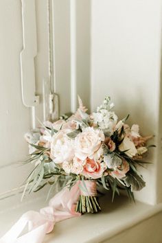 a bridal bouquet sitting on top of a window sill next to a door