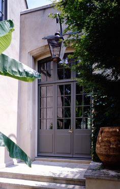 a house with steps leading up to the front door and entry way that is surrounded by greenery