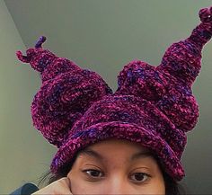 a woman wearing a purple knitted hat with horns