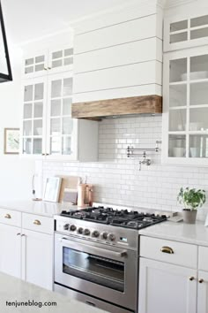 a kitchen with white cabinets and an oven