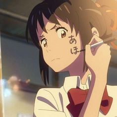 an anime character holding a cell phone to her ear