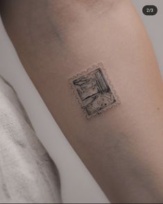 a small tattoo on the arm of a woman's left arm, with an image of a window