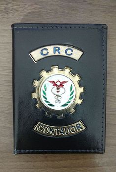 a black leather wallet with the emblem of a crc on it's front