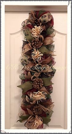 a wreath made out of burlocks and ribbons hangs on the front door,