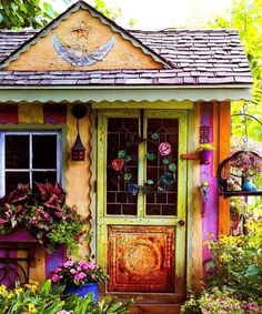 a colorful house with flowers and plants around it