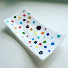 a white plate with multicolored dots on it