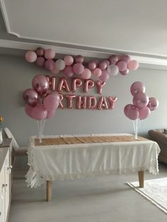 a birthday party with balloons and pink teddy bears on the wall, along with a sign that says happy birthday