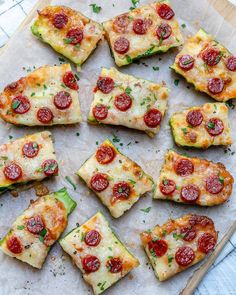 several slices of pizza with pepperoni and zucchini on a piece of parchment paper