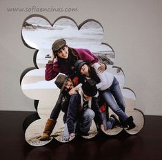 three people posing for a photo in front of a paper cutout with the shape of a cloud