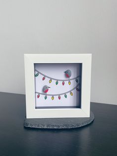 a white frame with lights on it sitting on a table next to a gray wall