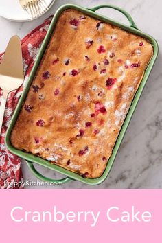 a close up of a cake in a pan on a table with a pink background