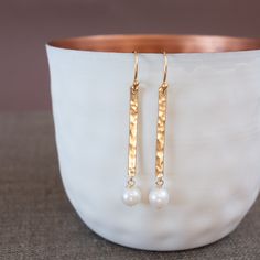 Modern and extraordinary. Those beautiful gold earrings are wearing hammered bars and real freshwater pearls in white. They add a very special accent to the outfit of your choice.  The ear hooks and the hammered bars are made of 14k Gold Fill and are therefore ideal for allergy sufferers. The pearls are real freshwater pearls with a high luster. You will receive a free pair of silicone stoppers for the scarf and hat season. Yay! D E T A I L S - Earrings: 14k Gold Fill - Pearls: freshwater pearls Hammered Gold Earrings, Elegant Hammered Everyday Earrings, Elegant Hammered Linear Earrings For Gift, Elegant Hammered Long Drop Earrings, Elegant Long Drop Hammered Earrings, Beautiful Gold Earrings, Brass Earrings Handmade, Drop Gold Earrings, Hammered Jewelry