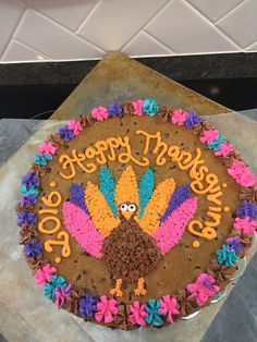 a birthday cake decorated like a turkey with happy thanksgiving written on it