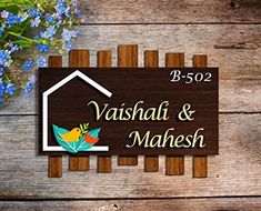 a wooden sign that says vasha & mahesh with flowers in the background