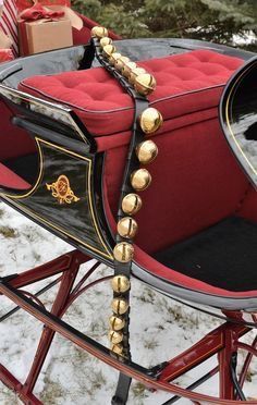 a red and black sleigh with gold trimmings on it's sides