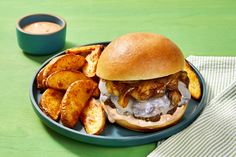 a hamburger and french fries on a blue plate