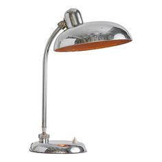 a chrome desk lamp with an orange shade on it's arm and a wooden base