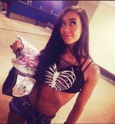 a woman holding a skateboard in her right hand and wearing a skeleton bra top