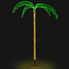 a lighted palm tree in the dark with its lights turned green and yellow on it