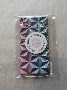 the packaging is wrapped in plastic and has geometric designs on it's front side