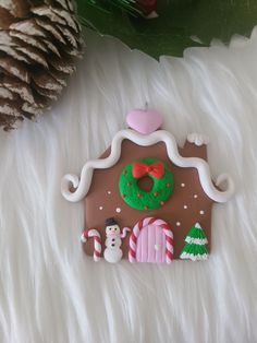 a gingerbread house ornament with candy and decorations on white furnishing