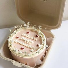 a birthday cake in a box with the words happy birthday written on it and flowers