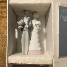 a wedding cake topper in a box with a bride and groom figurine