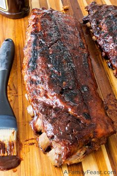 ribs and bbq sauce on a cutting board with a spatula next to it