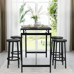 a kitchen table with four stools and a potted plant