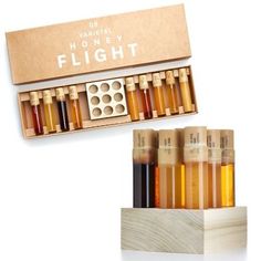 an assortment of different types of liquids in a wooden box next to a cardboard box