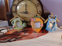 an old fashioned clock sitting on top of a table next to other decorations and decorating items