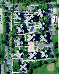 an aerial view of a parking lot with lots of cars parked in it and trees