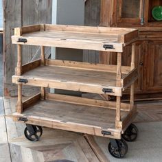 a wooden cart with three shelves on wheels