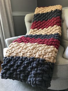 a crocheted blanket sitting on top of a white chair