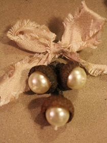 three pearls are laying on the sand next to two pine cones