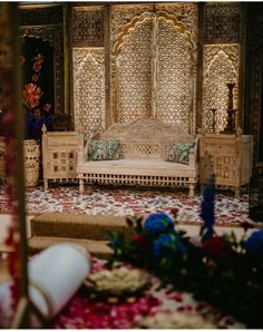 an elaborately decorated living room with flowers on the floor and furniture in front of it