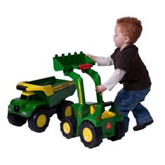 a little boy playing with a toy tractor