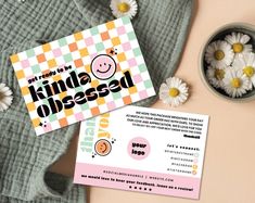 the business card is next to some daisies