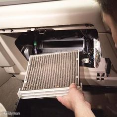 a man is removing the air filter from his car