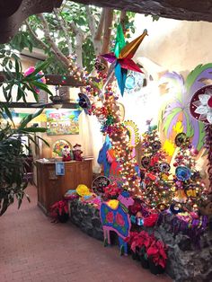 a room filled with lots of decorations on the wall and floor next to a tree