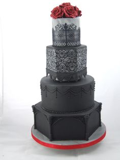 a three tiered cake with black lace and red roses on top is shown in front of a white background