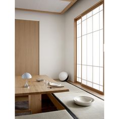 an empty room with a wooden table and white bowl on the floor next to it