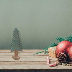 christmas decorations on a wooden table next to a small pine tree and other holiday items