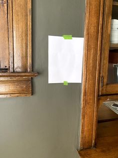 a piece of paper taped to the side of a cabinet