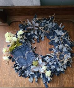 an old pair of jeans with flowers and leaves on it sitting on a wooden table