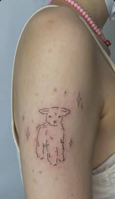 a woman with a small tattoo on her arm that has a sheep drawn on it