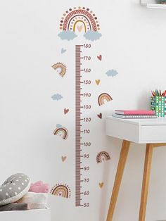 a child's growth chart wall sticker with rainbows and clouds