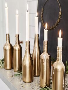 several bottles with candles in them sitting on a mantle